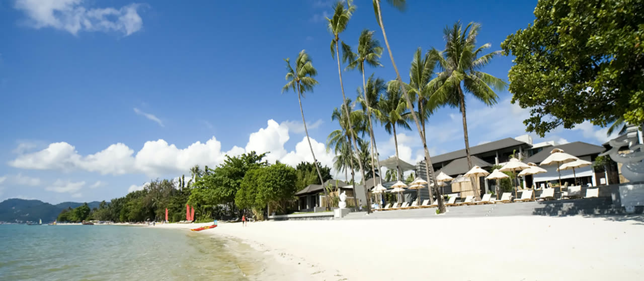 Chaweng Beach with palm trees, white sand and resort villas along the shore