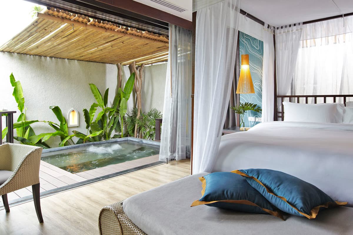 Canopy bed opening onto a small garden plunge pool