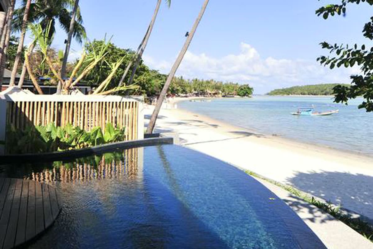 Pool edge with a plunge pool curving toward the beach and bay
